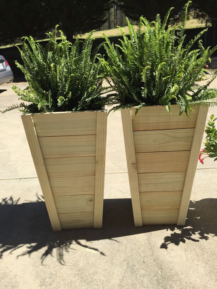 two wooden planters with plants growing out of them