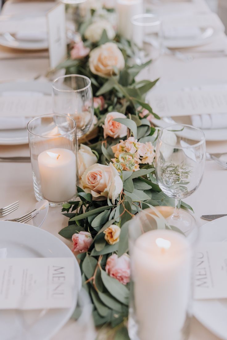 the table is set with candles, plates and napkins for an elegant wedding reception