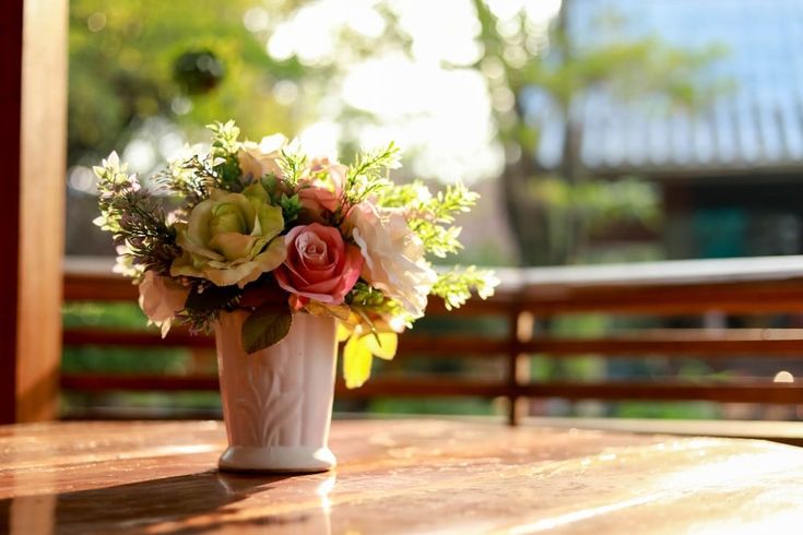 a vase filled with flowers sitting on top of a wooden table