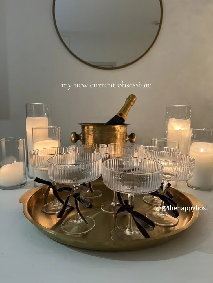 there is a tray with wine glasses and candles on it