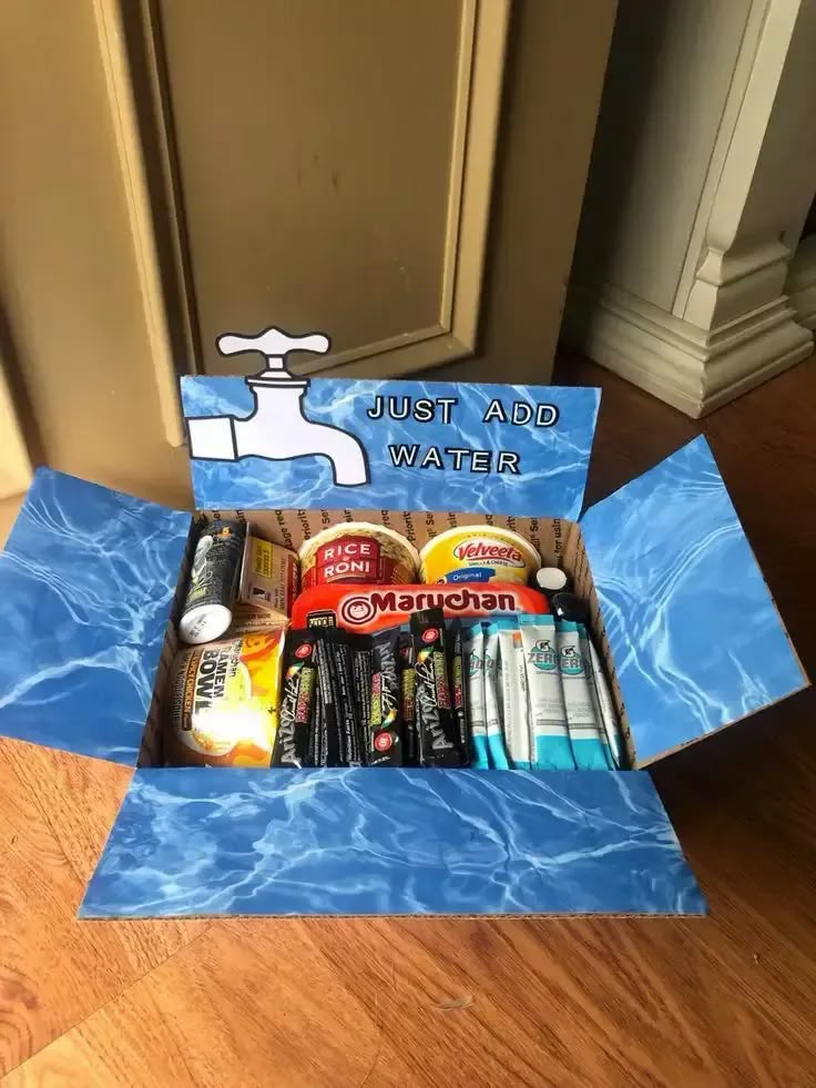 an open cardboard box with various items in it sitting on the floor next to a door