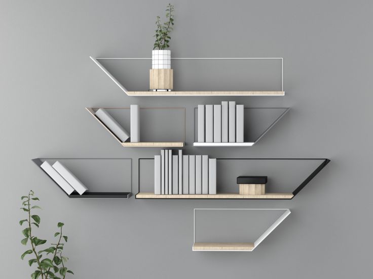 three shelves with books and plants on them against a gray wall next to a potted plant