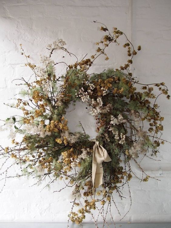 a wreath with dried flowers hanging on a wall