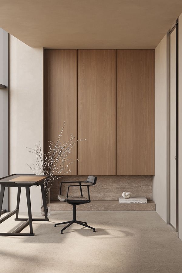 an empty room with a chair, table and vase on the floor next to it