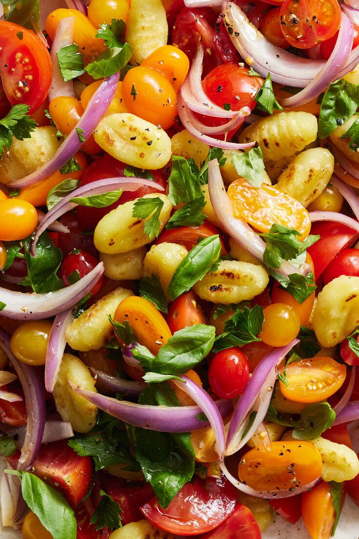 a salad with tomatoes, onions and other vegetables