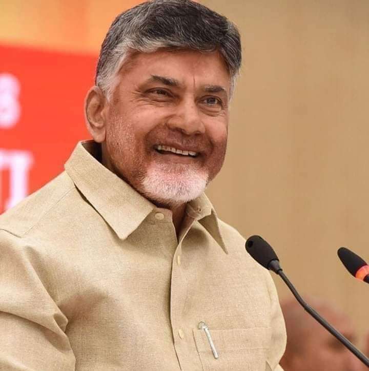 an older man smiles as he stands behind a microphone