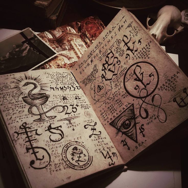 an open book with various symbols and numbers on the pages, sitting on top of a table