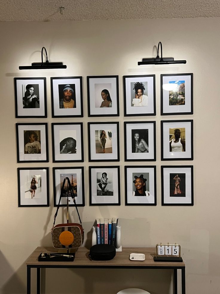 there is a table with many pictures on the wall and a purse sitting on it