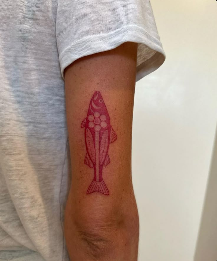 a person with a fish tattoo on their arm