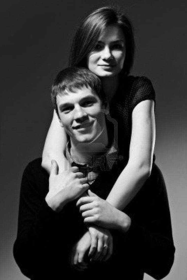 black and white photo of a young man hugging a woman's neck with her arm around him