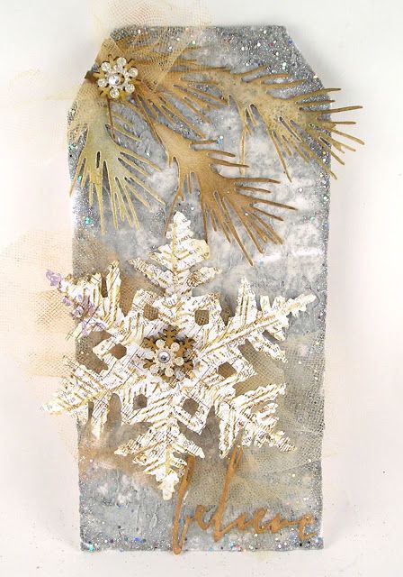 a snowflake is sitting on top of a piece of paper with gold foil