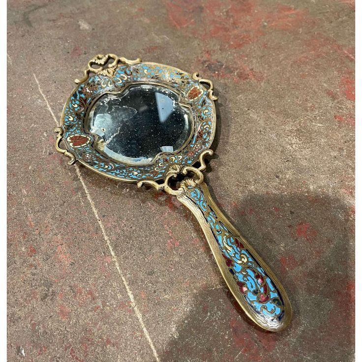 an antique looking mirror sitting on the ground