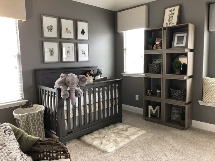 a baby's room with gray walls and pictures on the wall