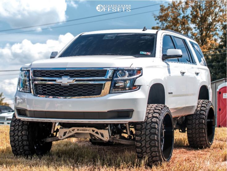 a white truck parked on top of a dry grass field