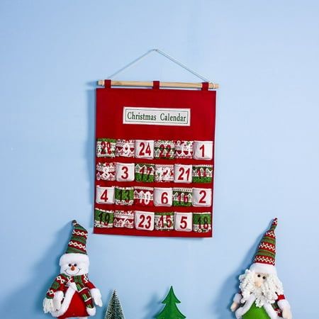 christmas calendar hanging on the wall with santa and snowman figurines next to it