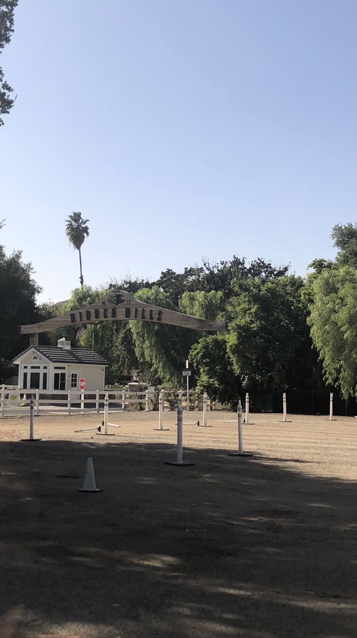 an open field with trees and fencing around it