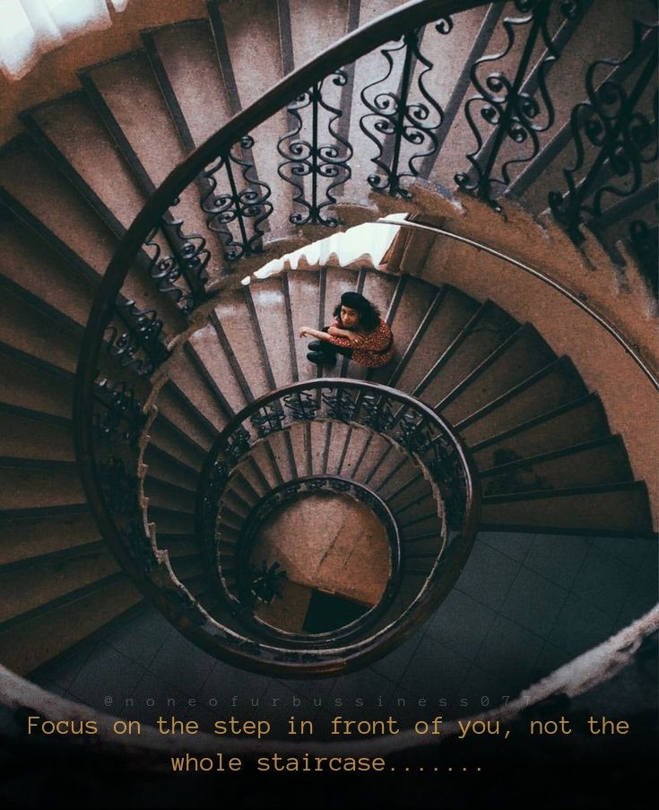 a man sitting on top of a spiral staircase