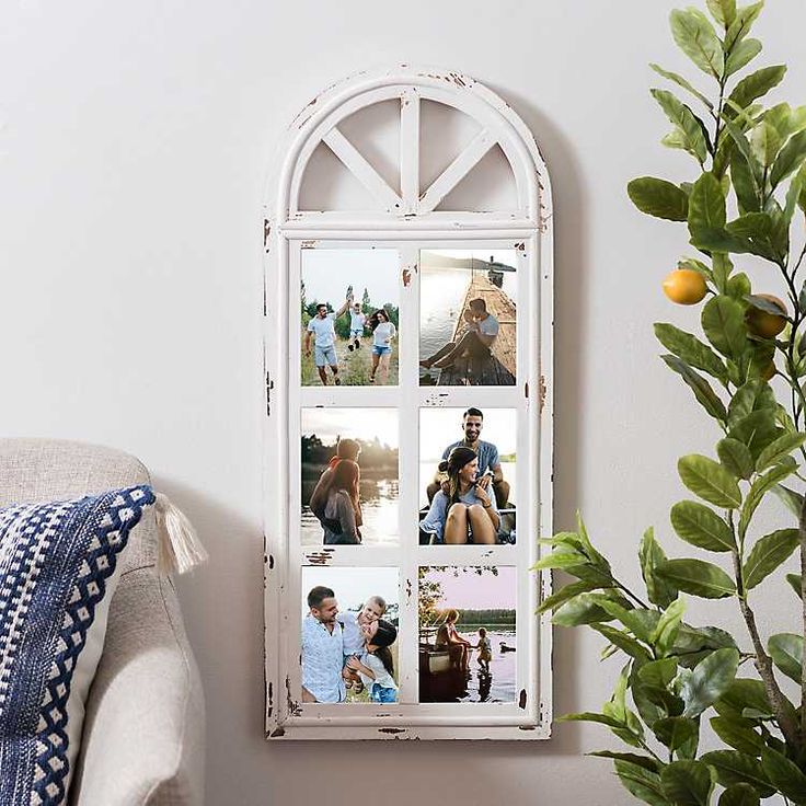 a white window frame with pictures on it next to a potted plant and pillow