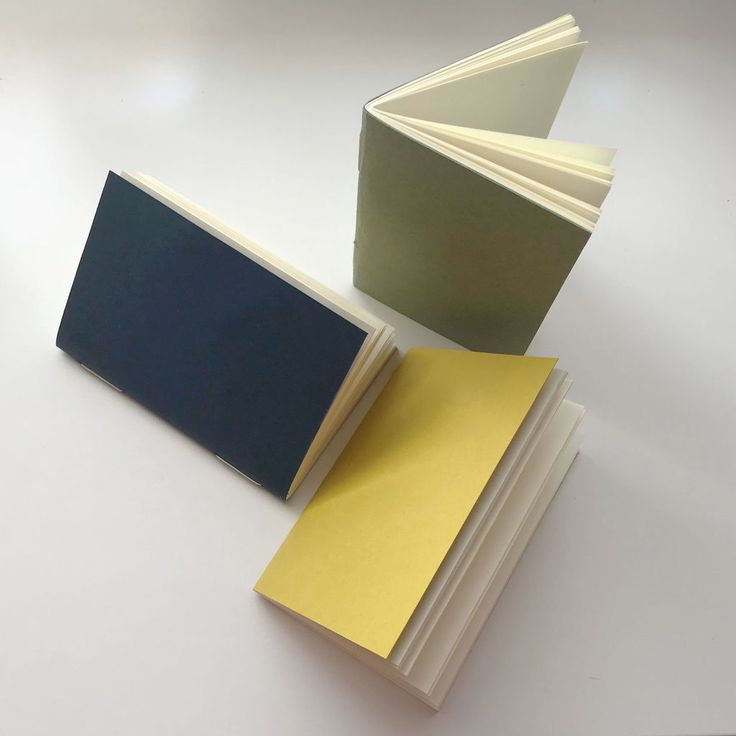 three books are stacked next to each other on a table with yellow and blue covers