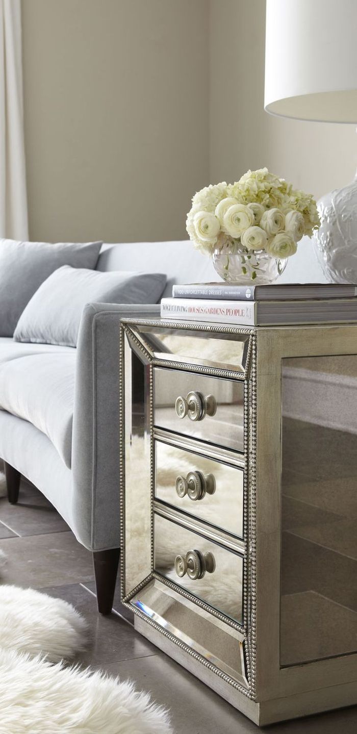 a living room with a couch, table and flowers on top of the coffee table