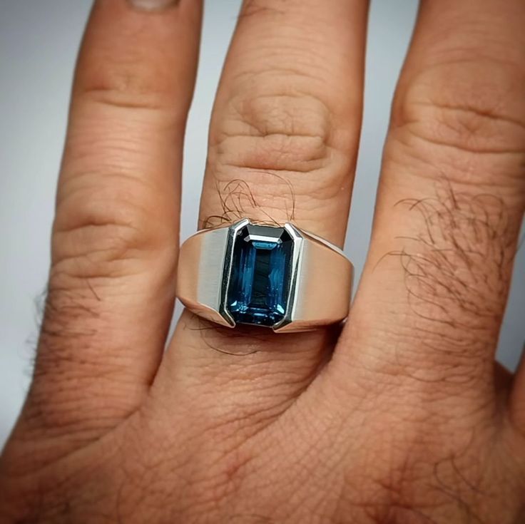 Welcome To JEWELRYSCAPEBoutique All OUR GEMSTONES ARE NATURAL NOT LAB CREATED  ALL OUR JEWELRY IS HANDCRAFTED IN THE INDIA.  Center Stone :London Blue Topaz Stone Size: 8×12 MM EMERALD CUT Material :Sterling Silver Finish With Rhodium. Mens Statement Ring, Stone Rings For Men, Stone Ring Design, Mens Gemstone Rings, S Ring, Mens Gold Jewelry, London Blue Topaz Ring, Wrist Game, Blue Topaz Stone