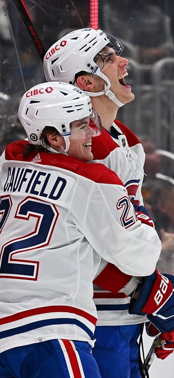 two hockey players hugging each other on the ice