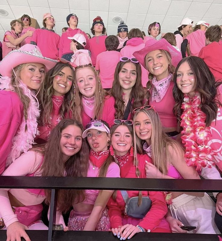 a group of women in pink outfits posing for a photo