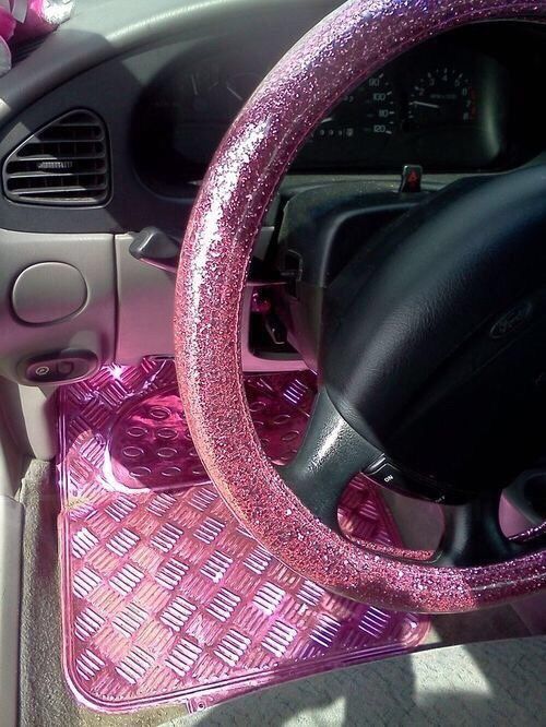 the interior of a car with pink carpet and steering wheel cover on it's dashboard