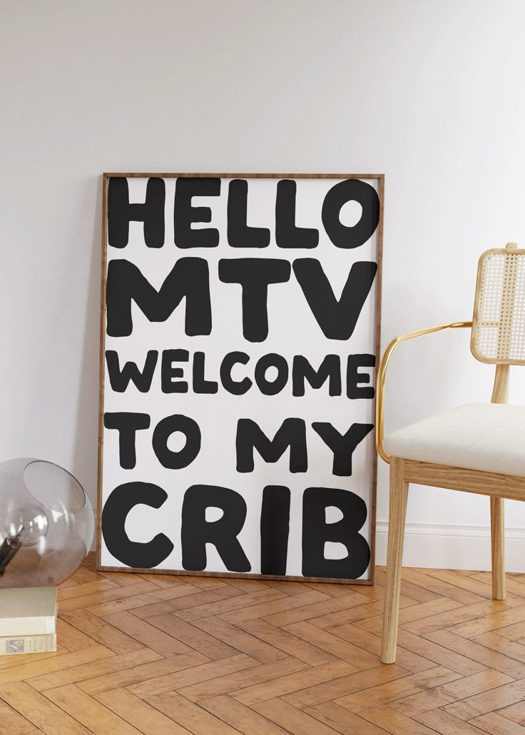 a black and white sign sitting on top of a wooden floor next to a chair