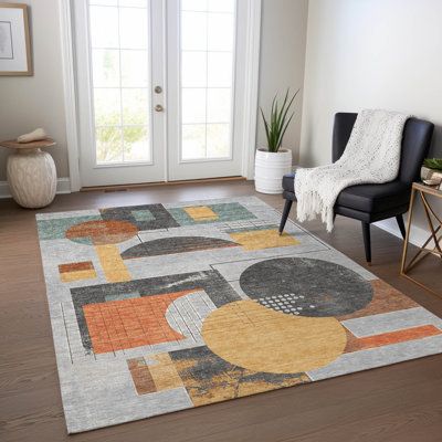 a living room area with a chair and rug on the hardwood floor next to a door