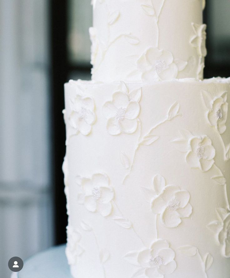 a three tiered white wedding cake with flowers on it