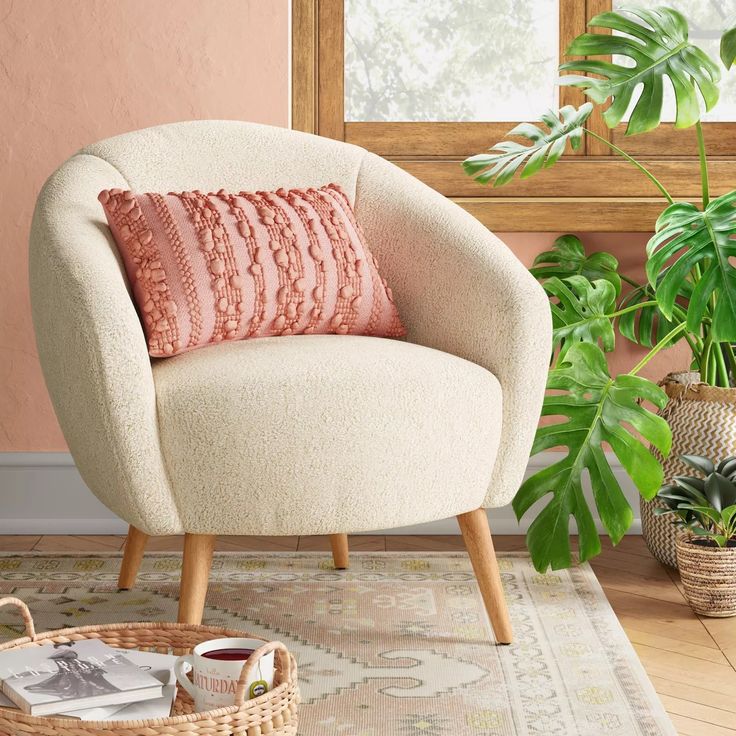 a living room with a chair, rug and potted plant in the corner on the floor