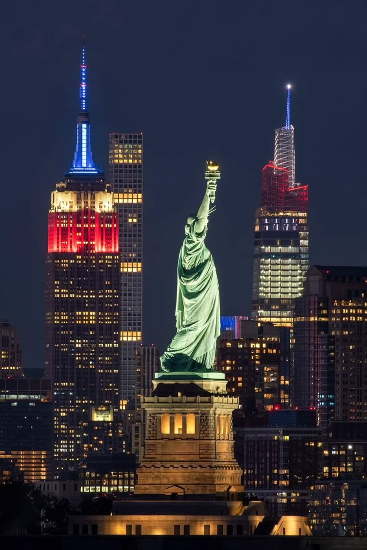 the statue of liberty lit up in red, white and blue