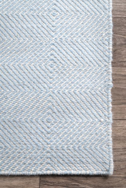 a blue and white rug sitting on top of a wooden floor next to a wood floor