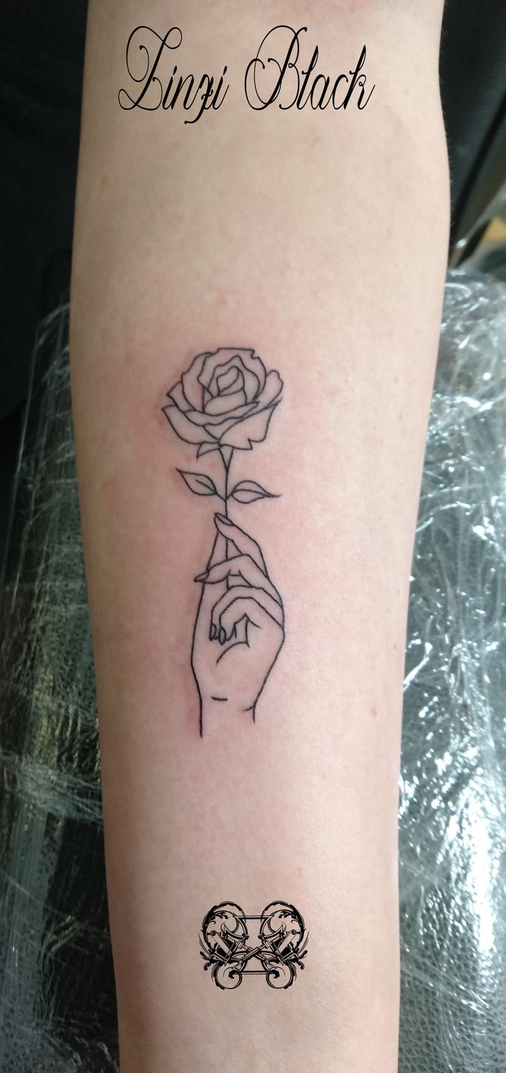 a tattoo on the arm of a woman with a rose and two hands holding each other