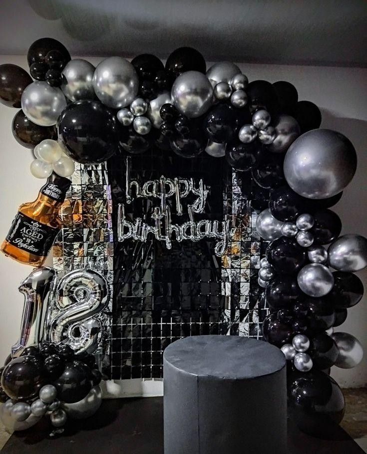 a black and silver birthday party with balloons, decorations and liquor bottles on the table