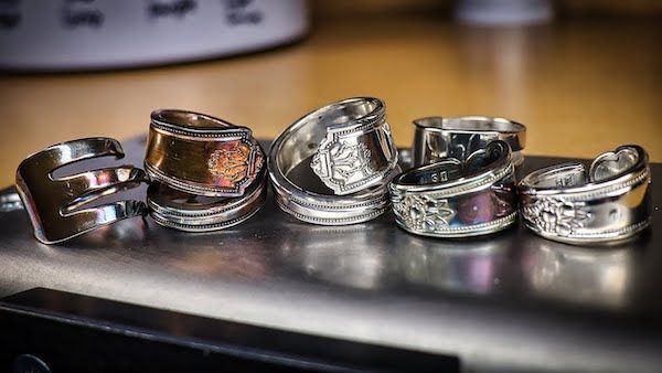 several different types of rings sitting on top of a metal table next to each other