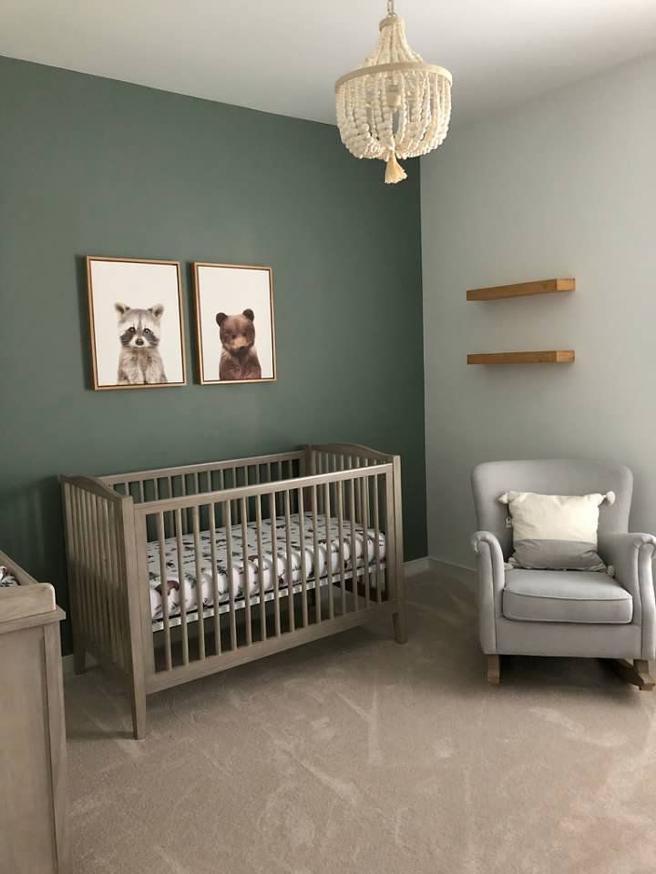 a baby's room with two pictures on the wall and a crib in the foreground