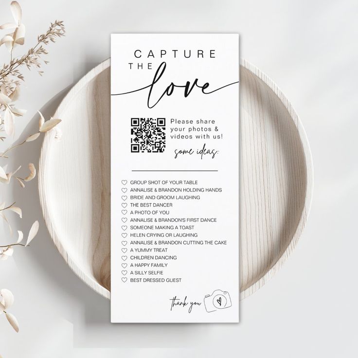 a table setting with a white plate and menu card on it that says capture the love