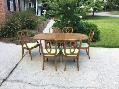 a dining table and six chairs in front of a house