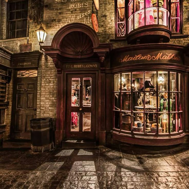 an old fashion store in the middle of a cobblestone street at night time