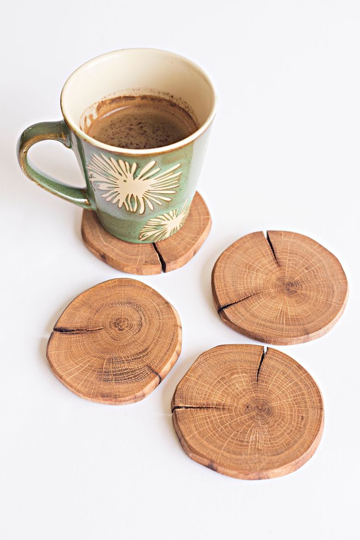 four wooden coasters sitting next to a cup of coffee