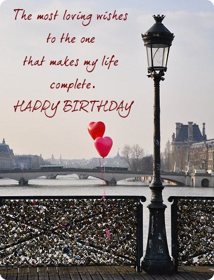 a couple of balloons that are sitting on a street light pole in front of a bridge