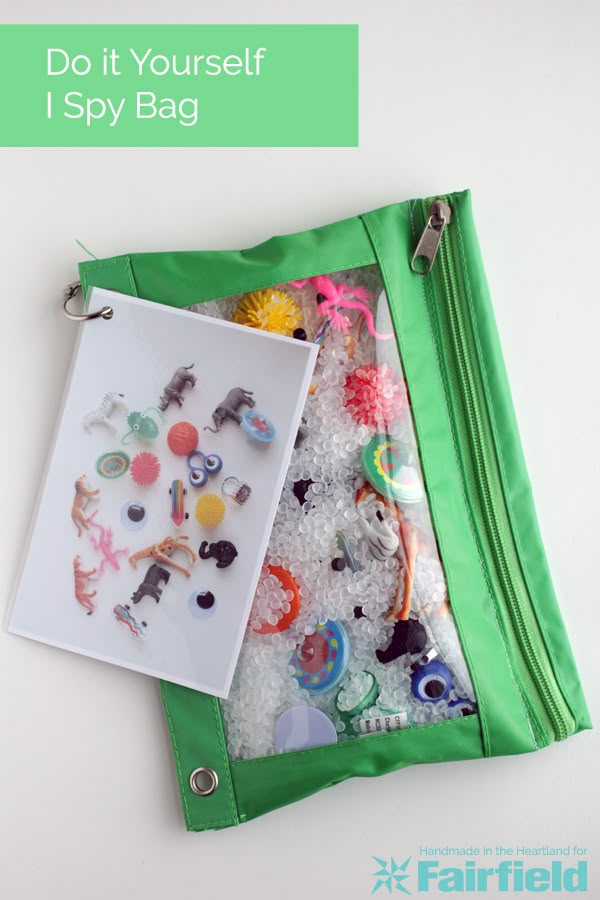 a green bag filled with lots of different types of buttons and pins next to a white wall