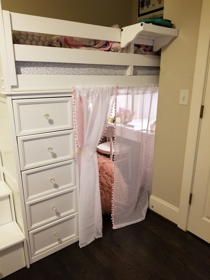 a white bunk bed sitting next to a dresser under a window with pink curtains on it