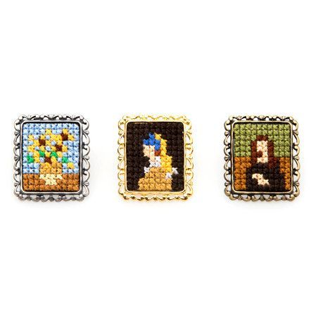 three square beaded brooches with princesses on them