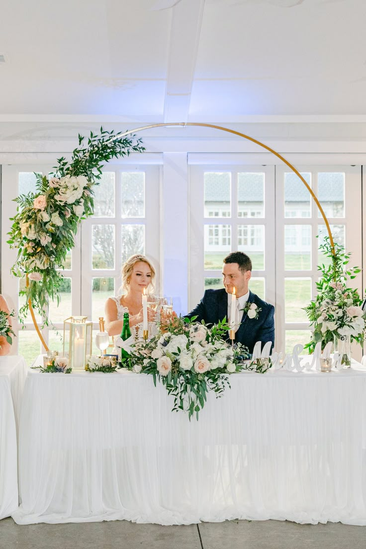 a bride and groom sitting at their wedding table