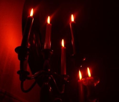 a chandelier with lit candles in the dark