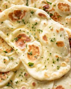 several flat breads with herbs on them