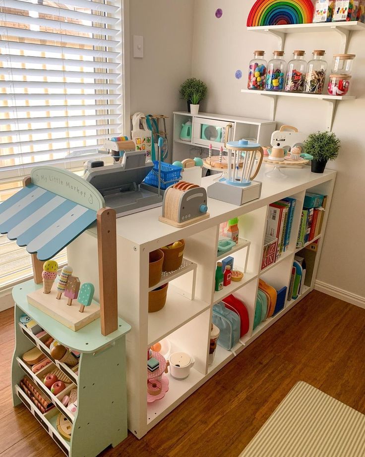 a child's play room with toys and bookshelves